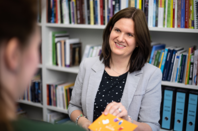 Abbildung Karolin Weide vor Bücherregal